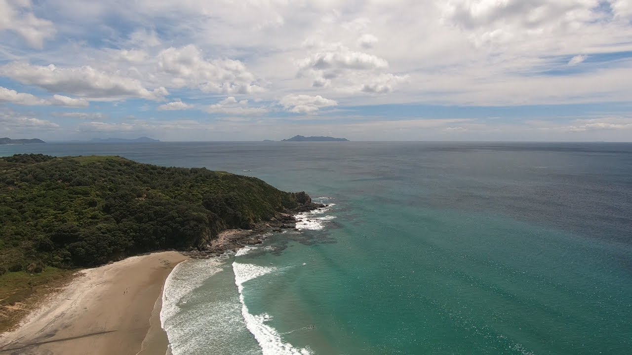 Wide shoreline view suggesting gentle outdoor movement blended with daylight on the New Zealand coast